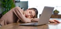 Tired exhausted sleepy Asian young female businesswoman freelancer sitting napping sleeping on table resting relaxing from home Royalty Free Stock Photo