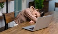 Tired exhausted sleepy Asian young female businesswoman freelancer sitting napping sleeping on table resting relaxing from home Royalty Free Stock Photo