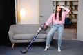 Tired and exhausted woman vacuuming house, cleaning rug carpet in living room, frustrated with doing much work about the house Royalty Free Stock Photo