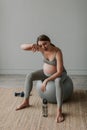 Tired expectant woman drink water from bottle breathing having rest on fitball. Royalty Free Stock Photo