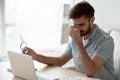 Stressed fatigued young man taking off glasses feeling eyestrain headache Royalty Free Stock Photo