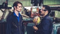 Tired factory workers taking a break and talking to coworker in the factory Royalty Free Stock Photo