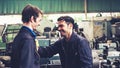 Tired factory workers taking a break and talking to coworker in the factory Royalty Free Stock Photo