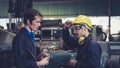 Tired factory workers taking a break and talking to coworker in the factory Royalty Free Stock Photo