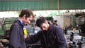 Tired factory workers taking a break and talking to coworker in the factory Royalty Free Stock Photo