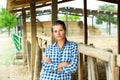 Tired farm worker stands near the corral