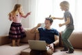 Tired father with his two kids during quarantine. Home office concept. Online working and household at the same time while