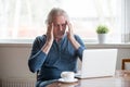 Tired senior man touching temples feeling headache working on la Royalty Free Stock Photo