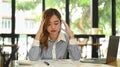 Tired female employee holding her head, feeling strong headache, exhausted from overwork or stress at work Royalty Free Stock Photo