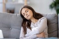 Tired female fall asleep on couch with book in hands