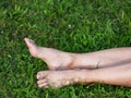 Tired female legs with bare feet on the green grass. Mature woman Royalty Free Stock Photo