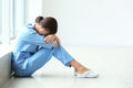 Tired female nurse sitting on floor in hospital Royalty Free Stock Photo