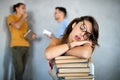 Tired female student sleeping on the books in the library Royalty Free Stock Photo