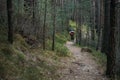 Tired female tourist hiking on the path in the wild forest and exhausted of heavy trek. Independent travel alone with