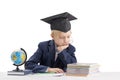 Tired first grader boy in students hat does his homework. Bored schoolboy isolated on white background. Education concept Royalty Free Stock Photo