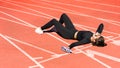 Tired fit woman resting after workout or running, holding a bottle of water, taking a break during training Royalty Free Stock Photo