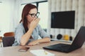 Tired freelancer woman yawning at laptop