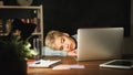 Tired freelancer working on laptop at home until late evening Royalty Free Stock Photo