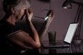 Tired and frustration elderly woman working and using laptop at late night Royalty Free Stock Photo