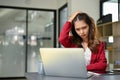 Tired and furious Asian businesswoman looking at laptop screen, having internet connection issue Royalty Free Stock Photo