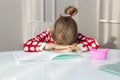 tired girl fell asleep on school exercise book, studying at home at her desk. child is doing homework. Hard task of reading and Royalty Free Stock Photo
