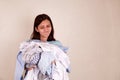 A tired girl is holding a pile of dirty laundry in her hands. Royalty Free Stock Photo