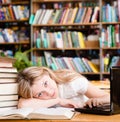 Tired girl in the library teaches before exams Royalty Free Stock Photo