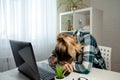 Tired girl resting her head on the table of working with compute