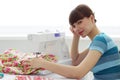 Tired girl seamstress and sewing machine Royalty Free Stock Photo