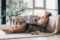 Tired girl is sitting on the floor of the bedroom leaning back on the bed Royalty Free Stock Photo