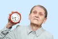 Tired grandmother with an alarm clock Royalty Free Stock Photo