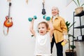 Tired granny doing phisical exercises with her grandson, tries to encourage him Royalty Free Stock Photo