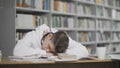 Tired guy falls asleep while studying At Library At College Royalty Free Stock Photo