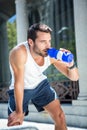 Tired handsome athletic drinking out of bottle