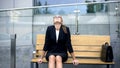 Tired but happy business woman sitting on bench, successful contract, hard work