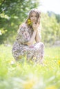 Tired but happy girl sitting on the lawn of the Park with a bouquet of flowers