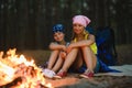 Tired and happy kids sitting at campfire