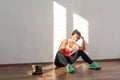 Tired happy sportswoman showing thumbs up to camera. indoor studio shot illuminated by sunlight