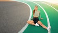 Tired happy woman runner taking rest after run sitting running track Royalty Free Stock Photo