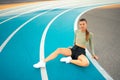 Tired happy woman runner taking rest after run sitting running track Royalty Free Stock Photo