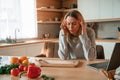 Tired, having headache. Beautiful young woman is on the kitchen