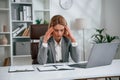 Tired, having headache. Woman in business formal clothes is working in office Royalty Free Stock Photo