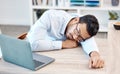 Tired, headache and sleeping worker behind laptop while lying his head on his desk in his office. Stress, burnout and Royalty Free Stock Photo