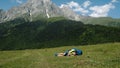 Tired hiker with a large backpack falls to the ground against the backdrop of a beautiful mountain landscape, a sick man