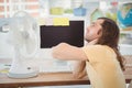 Tired hipster sitting by electric fan on desk