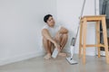 Tired househusband man sit on the floor after mopping the room. Royalty Free Stock Photo