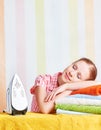 Tired housewife fell asleep on ironing board with iron Royalty Free Stock Photo