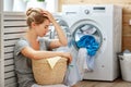 Tired housewife woman in stress sleeps in laundry room with wash