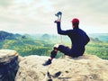 Tired hurt tourist with medicine crutches. Man with broken leg in knee brace features resting on exposed rocky summit Royalty Free Stock Photo