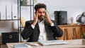 Tired indian business man suffering from headache problem tension, migraine, stress at home office Royalty Free Stock Photo